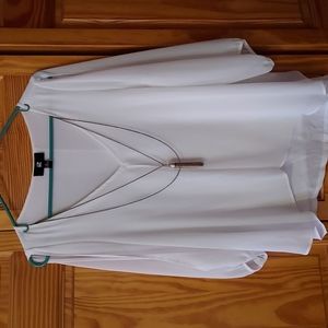 A flowy white sheer blouse great for the summer time that has a necklace too.